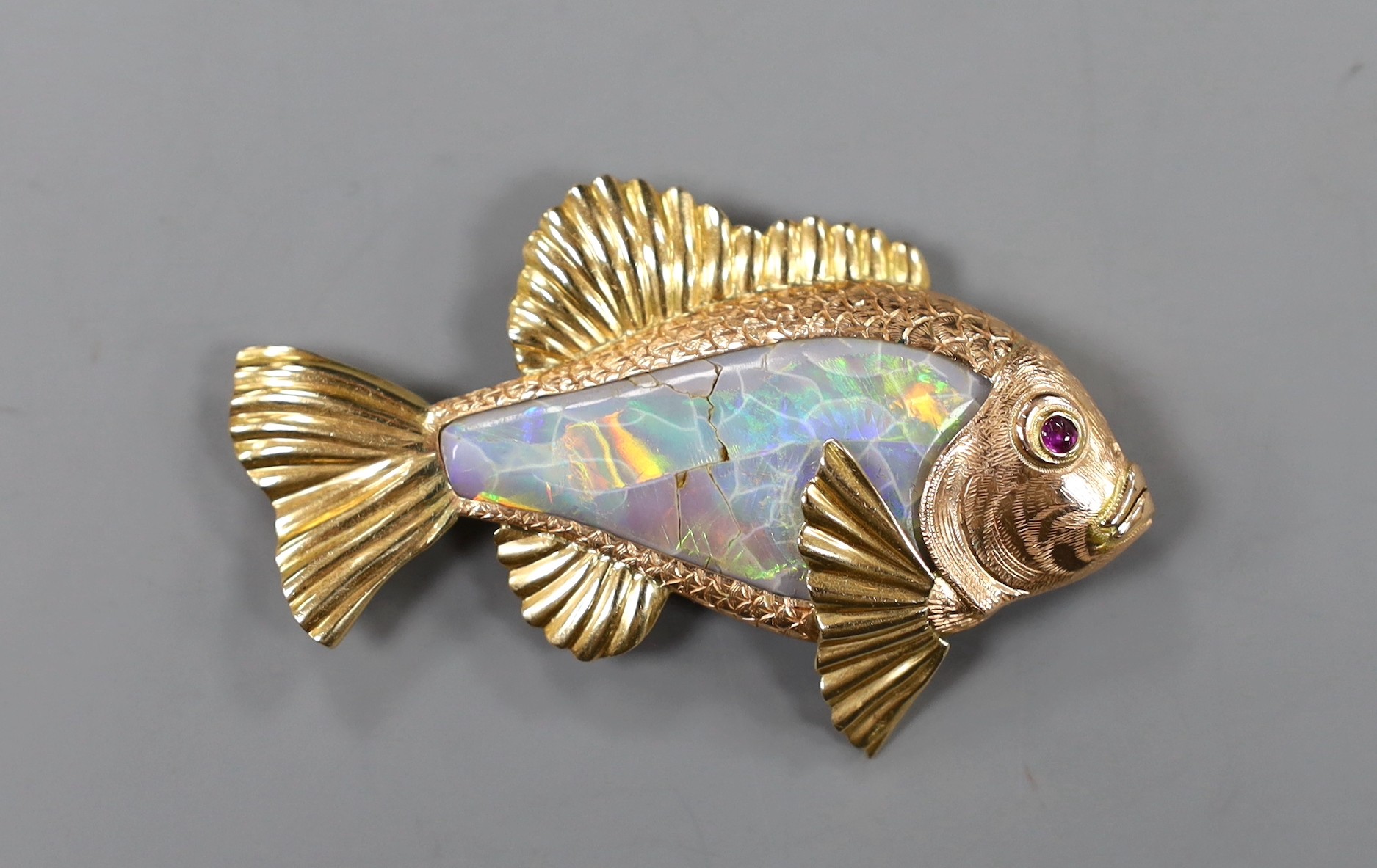 A yellow metal mounted white opal set brooch, modelled as a fish, with cabochon set eye, 60mm, gross weight 16 grams, opal a.f.